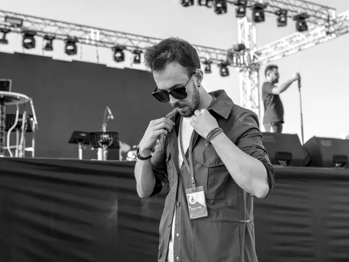 Crew member with an access pass in front of a stage during soundcheck