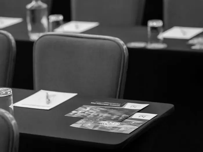 Conference room set up with notepads and water, ready for attendees