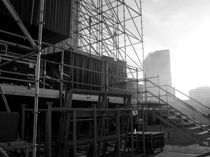Stage scaffolding being built on an outdoor festival site