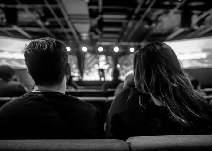 Conference audience in front of large stage screens