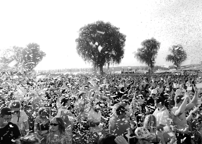 Huge festival crowd celebrating under a shower of confetti